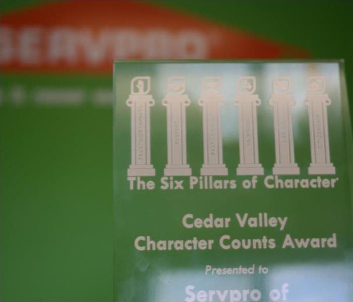 A extreme close up of a glass award with white etching text that reads Character Count Award.