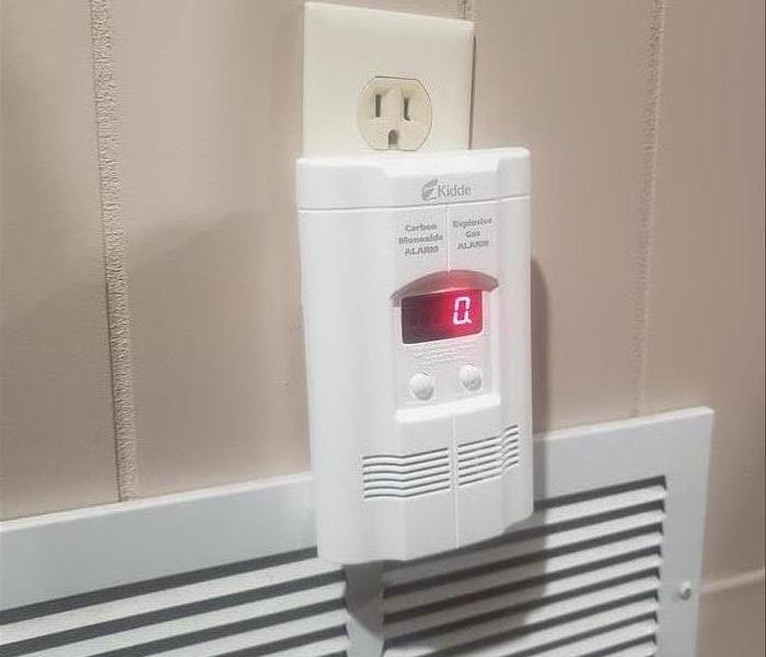 An image of a plug-in CO alarm near bedroom.