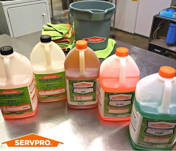 Cleaners on stainless steel table, and SERVPRO logo